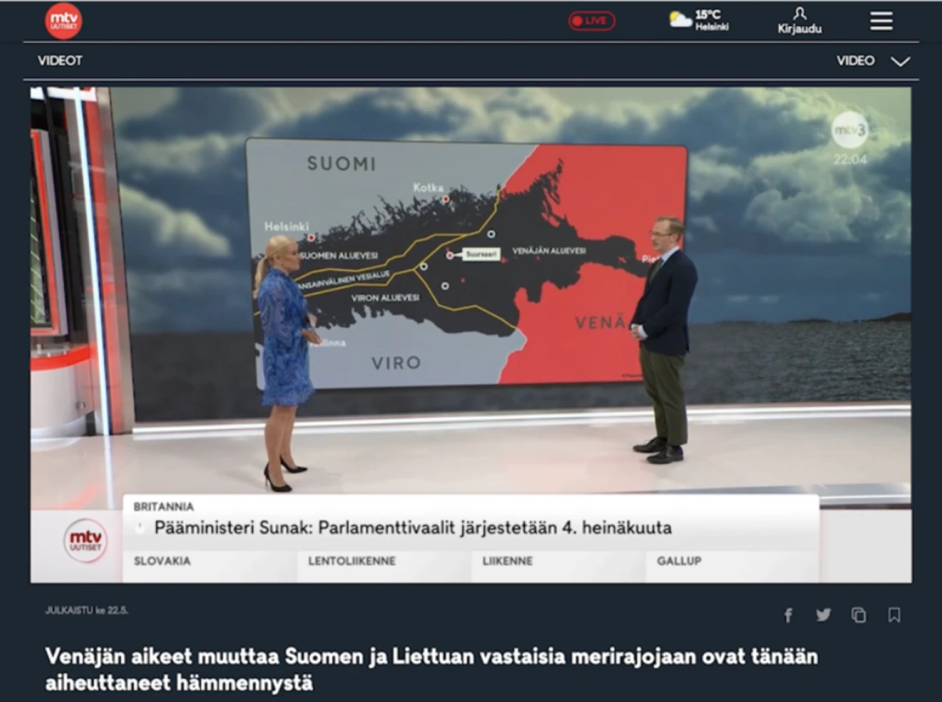A Finnish television news studio shows two presenters standing in front of a large digital map illustrating maritime borders between Finland, Estonia, and Russia, with regions highlighted in contrasting colors.