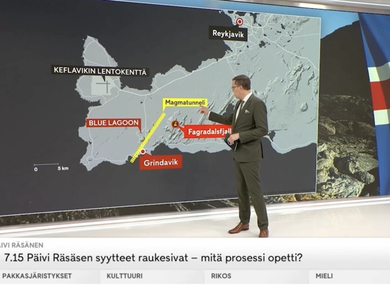 A news presenter gestures toward a detailed map of southwestern Iceland highlighting towns, an airport, volcanic sites, and infrastructure, used to explain recent geological activity.